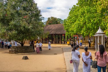 KANDY, SRI LANKA - 31.2021 ARALIK: Kandy 'deki Diş Tapınağı' nda insanlarla dolu bahçe. Budist tapınağı Sri Dalada Maligawa