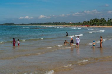 BENTOTA, SRI LANKA - HAZİRAN 02.2021 Kıyı ve okyanusta insanlar, Hint Okyanusu Bentorta Sahili, Sri Lanka