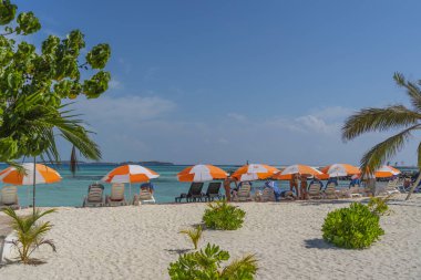 MAAFUSHI, MALDIVES - Şubat 2022: Maafushi Adası, Maldivler. güneş şemsiyesi ve güneş yatağı