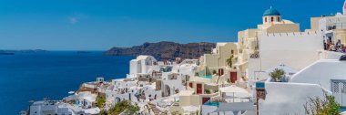 OIA, GREECE - 22 Mayıs 2022: Geleneksel beyaz evleri olan Oia 'nın güzel manzarası, Santorini Adası, Yunanistan