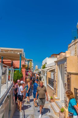 OIA, GREECE - 22 Mayıs 2022: Geleneksel beyaz evleri olan Oia hediyelik eşya dükkanları, Santorini Adası, Yunanistan