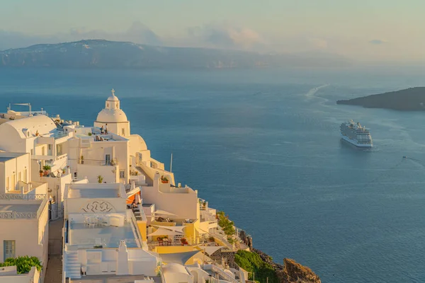 FIRA, GREECE - MAY 21.2022: White houses from Fira, the capital of Santorini island, background the sea