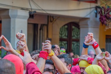 CAMBRILS, İspanya - SEPTEMBER 04.2022: Hands at a Castells Performance, Castell Tarragona 'daki festivallerde geleneksel olarak inşa edilen bir insan kulesidir.