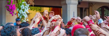 CAMBRILS, SPAIN - SEPTEMBER 04.2022: Hands at a Castells Performansı, Castell geleneksel olarak festival, panorama