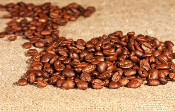 Coffee beans lying on sacking — Stock Photo, Image