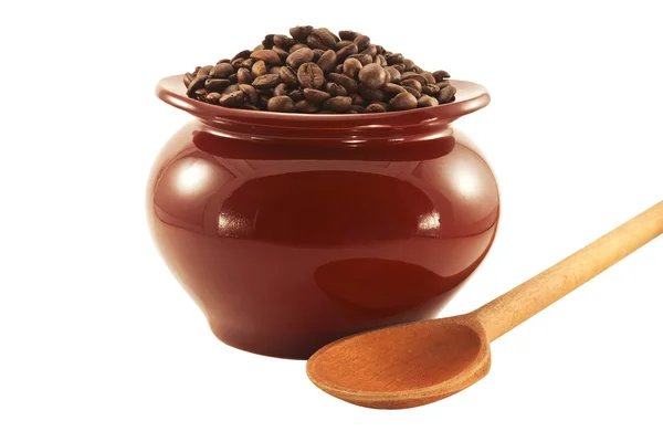 Granos de café en una olla con una cuchara de madera —  Fotos de Stock