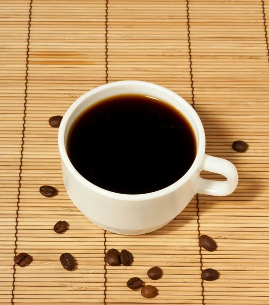 White coffee cup with coffee beans on the table — Stock Photo, Image