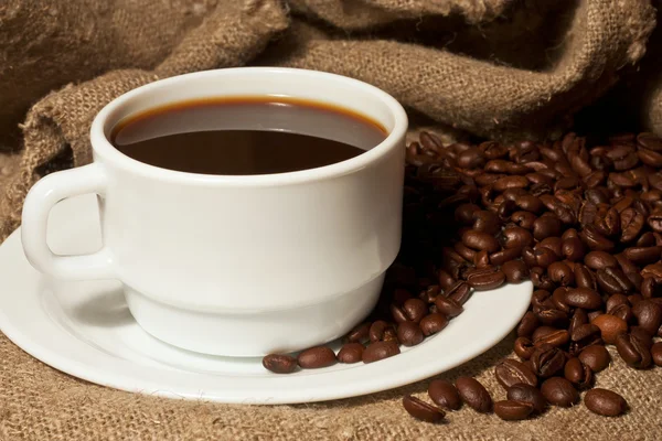 Tazza bianca di caffè con un sacco di iuta — Foto Stock