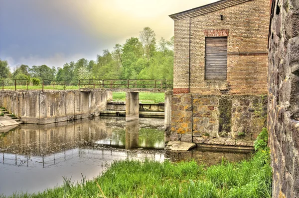 Oude kapotte molen aan de rivier — Stockfoto