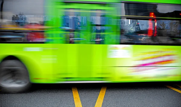 Trilhas de ônibus de alta velocidade e borradas na estrada do centro da cidade — Fotografia de Stock