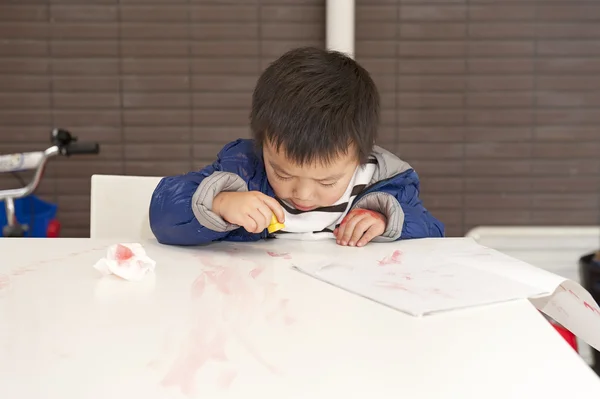 Een schattige baby is schilderen op tafel — Stockfoto