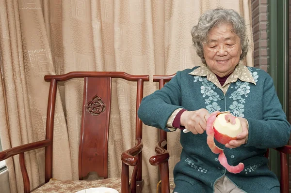 Grandmother peeling apple — Stock Photo, Image