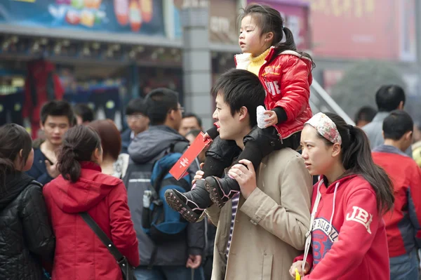 Una familia feliz pasa por una concurrida calle peatonal de compras — Foto de Stock