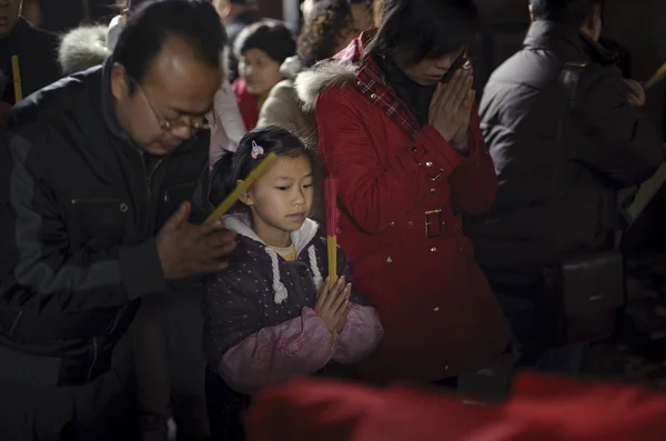 Crowded kneel down and praying to Buddha in temple — Stock Photo, Image