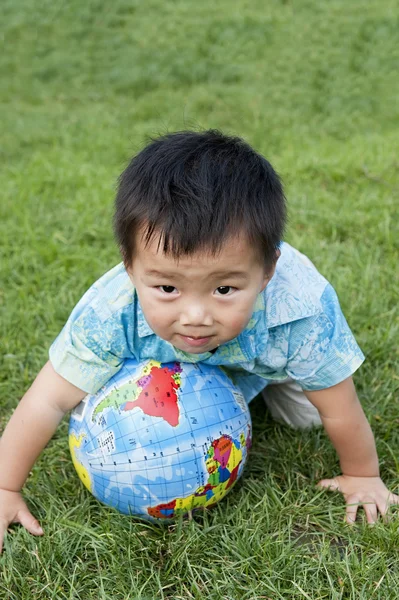 Barnet håller jorden modellen på gräset — Stockfoto