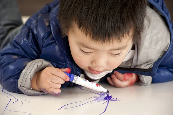 Um bebê bonito está pintando na mesa — Fotografia de Stock