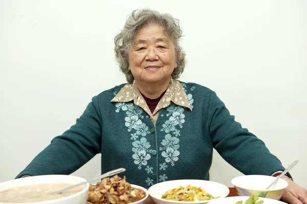 Sitting at the dinner table, happy grandmother — Stock Photo, Image