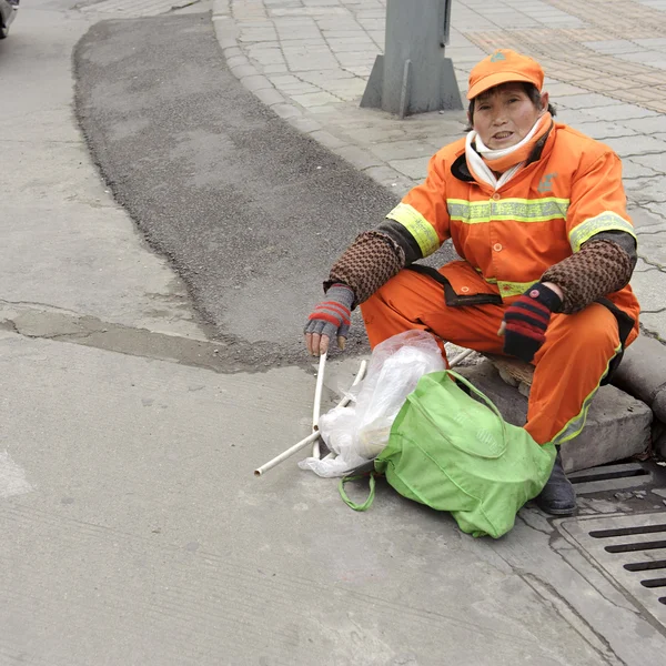 Cleaner sitting on the roadside — Stock Photo, Image