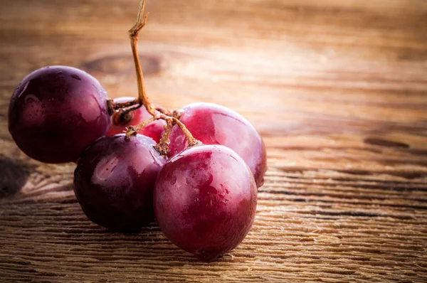 Red grape on wooden table, closeup — Stock Photo, Image