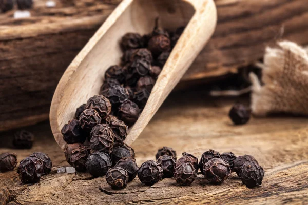 Black pepper on the wooden table — Stock Photo, Image