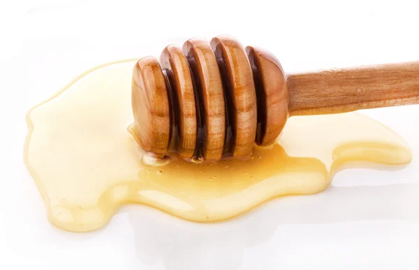 Trempette au miel en bois et gouttes de miel — Photo