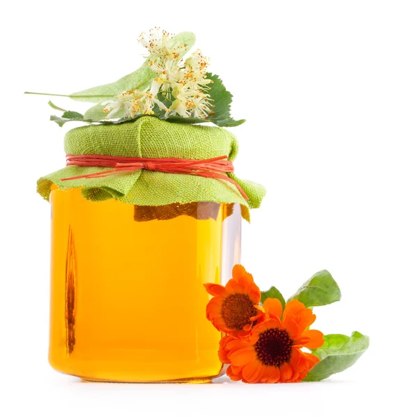 Honey in glass jar with flowers — Stock Photo, Image