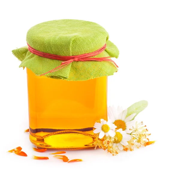 Honey in glass jar with flowers — Stock Photo, Image