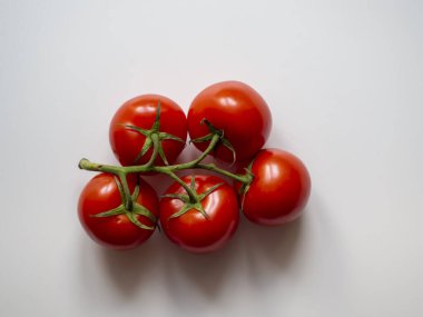 Beyaz arka planda dalları olan taze domatesler izole edilmiş.