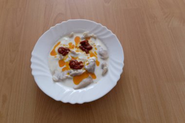 Ev yapımı Türk manti makarnası yenmeye hazır. Sarımsaklı yoğurt sosu. Zeytinyağı ve acı biber sosu 5 dakika kaynatıldı, hepsi bu.