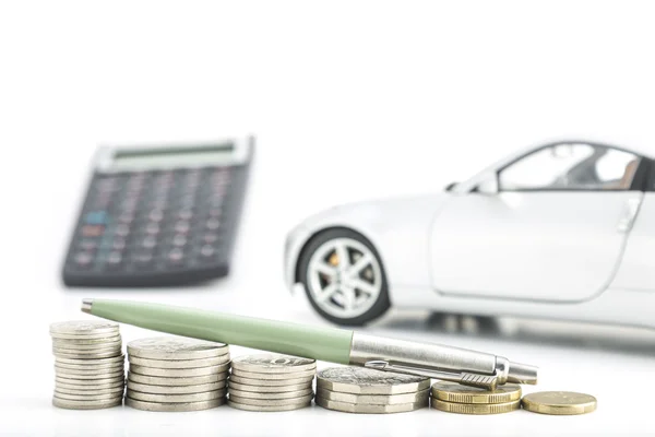 Monedas con coche, pluma y calculadora — Foto de Stock