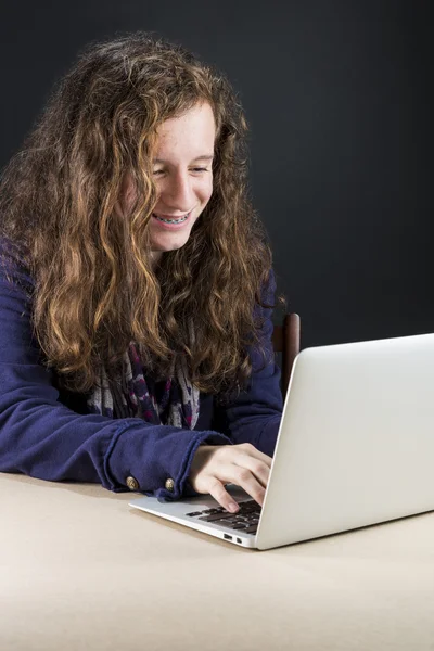 Teen sitting at table with a laptop — Stock Photo, Image