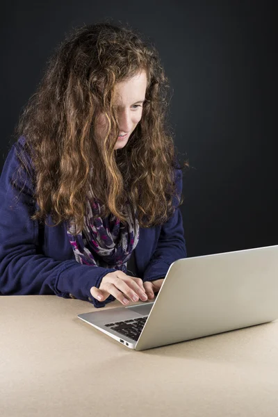 Teen sitting at table with a laptop — Stock Photo, Image