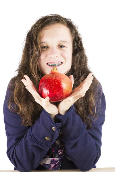 Tonåring håller ett granatäpple Stockbild
