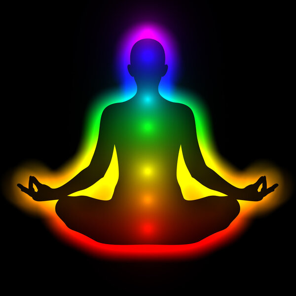 Silhouette of woman in meditation with aura and chakras