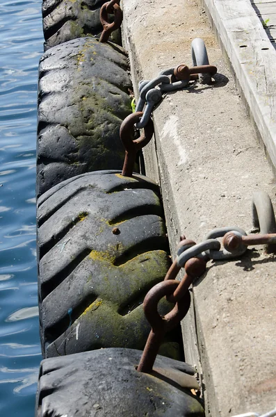 Tires chained to pier — Stock Photo, Image