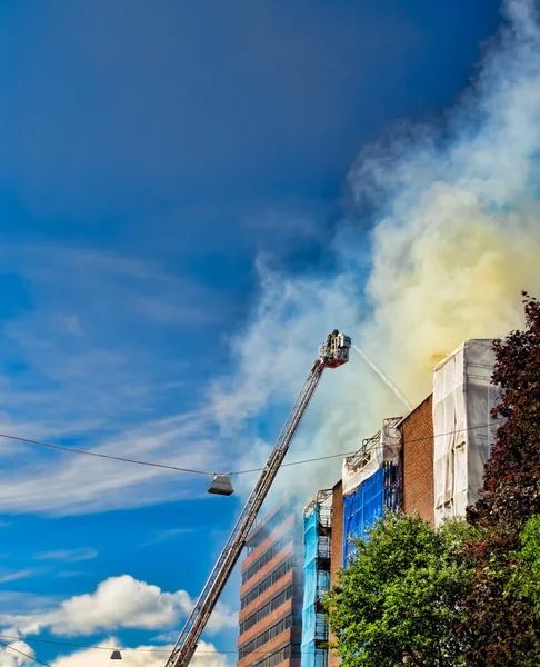 Pompiers sur une échelle éteignant un incendie — Photo