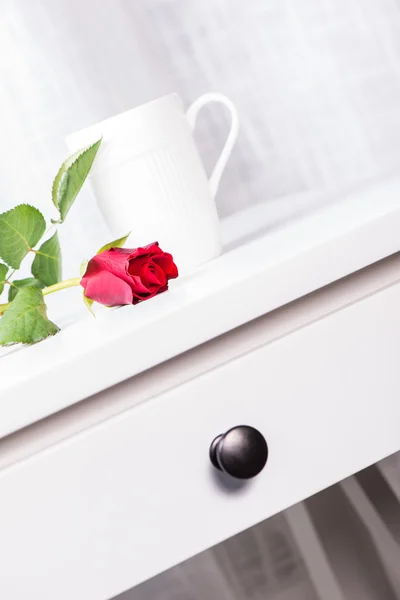 Cup and rose on white table — Stock Photo, Image