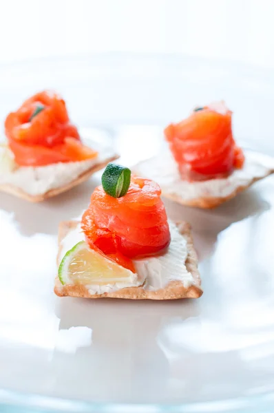 Canapés con queso salmón lima y romero en plato blanco —  Fotos de Stock
