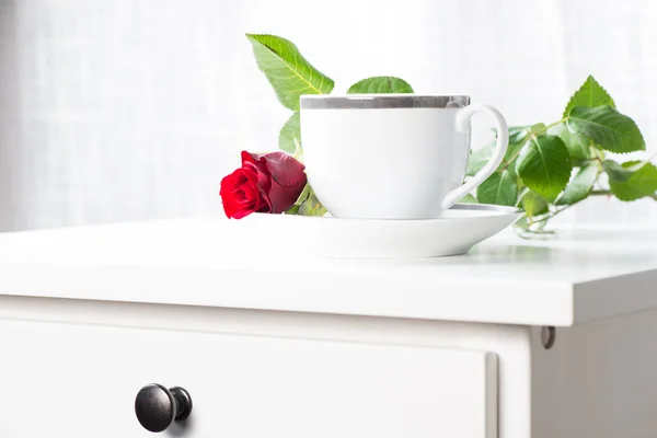White coffee cup and single red rose — Stock Photo, Image