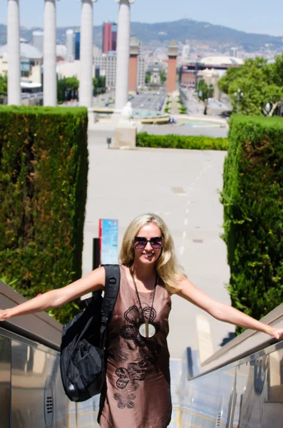 Smiling young woman standing on stairs — Stock Photo, Image