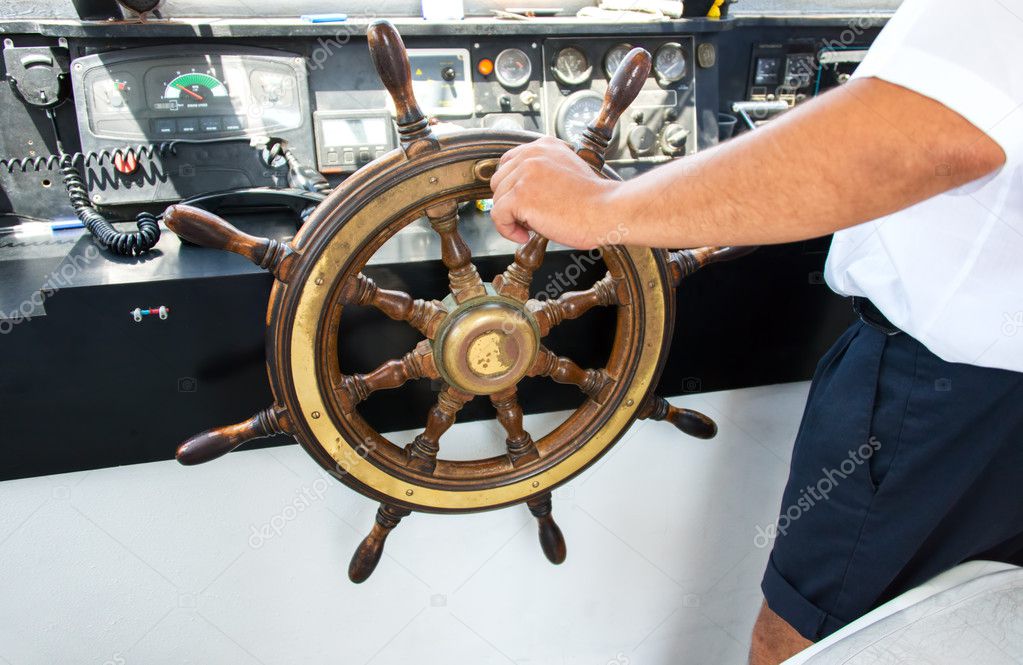 Capitan hand steering a boat