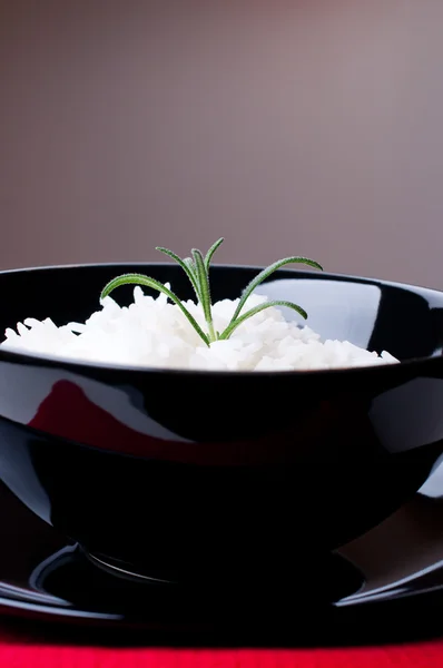Gekookte rijst in zwarte kom met rode servet — Stockfoto