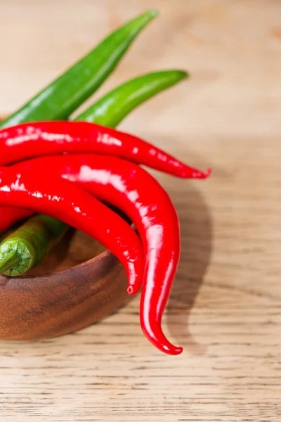 Fresh red and green chili peppers on wooden bowl — Stock Photo, Image