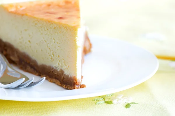 Bolo de queijo com garfo de bolo em uma chapa na toalha de mesa — Fotografia de Stock