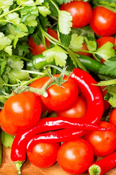 Tomaten und rote Chilischoten auf Holztisch — Stockfoto