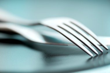 Artistic cutlery fork and knife macro on plate clipart