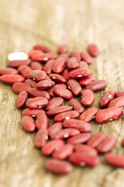 Sušené červené fazole na dřevěný stůl — Stock fotografie