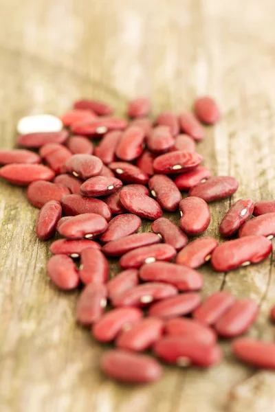 Frijoles rojos secos sobre una mesa de madera —  Fotos de Stock