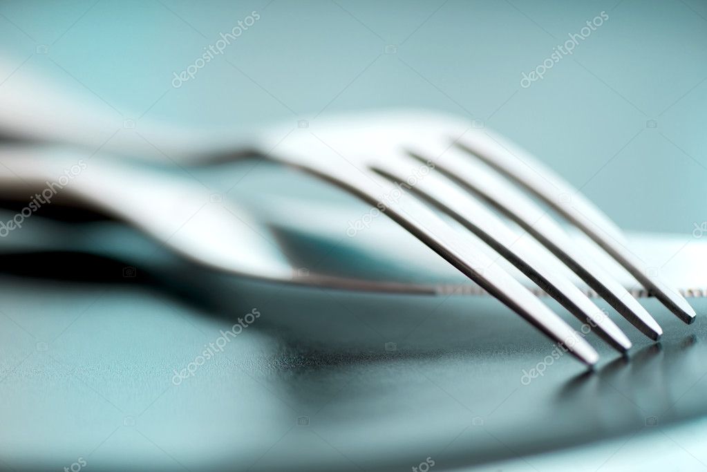 Artistic cutlery fork and knife macro on plate