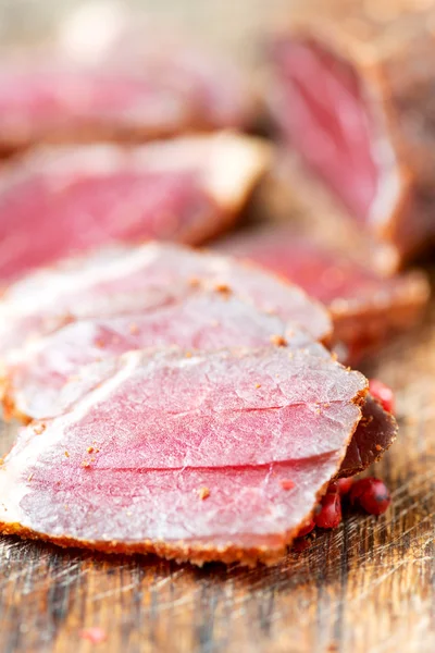 Slices of cured meet and pepper on table close up — Stock Photo, Image